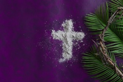 Border of cross of ashes, palm branch leaves and partial crown of thorns on a dark purple background with copy space